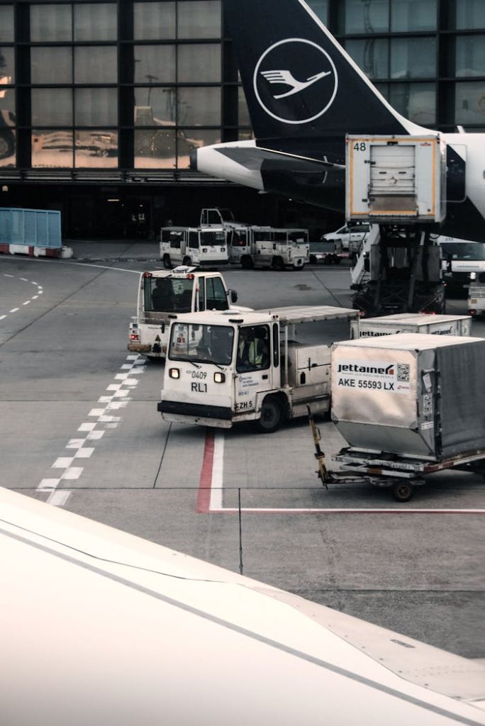An airport ramp scene with ground support vehicles and cargo operations.